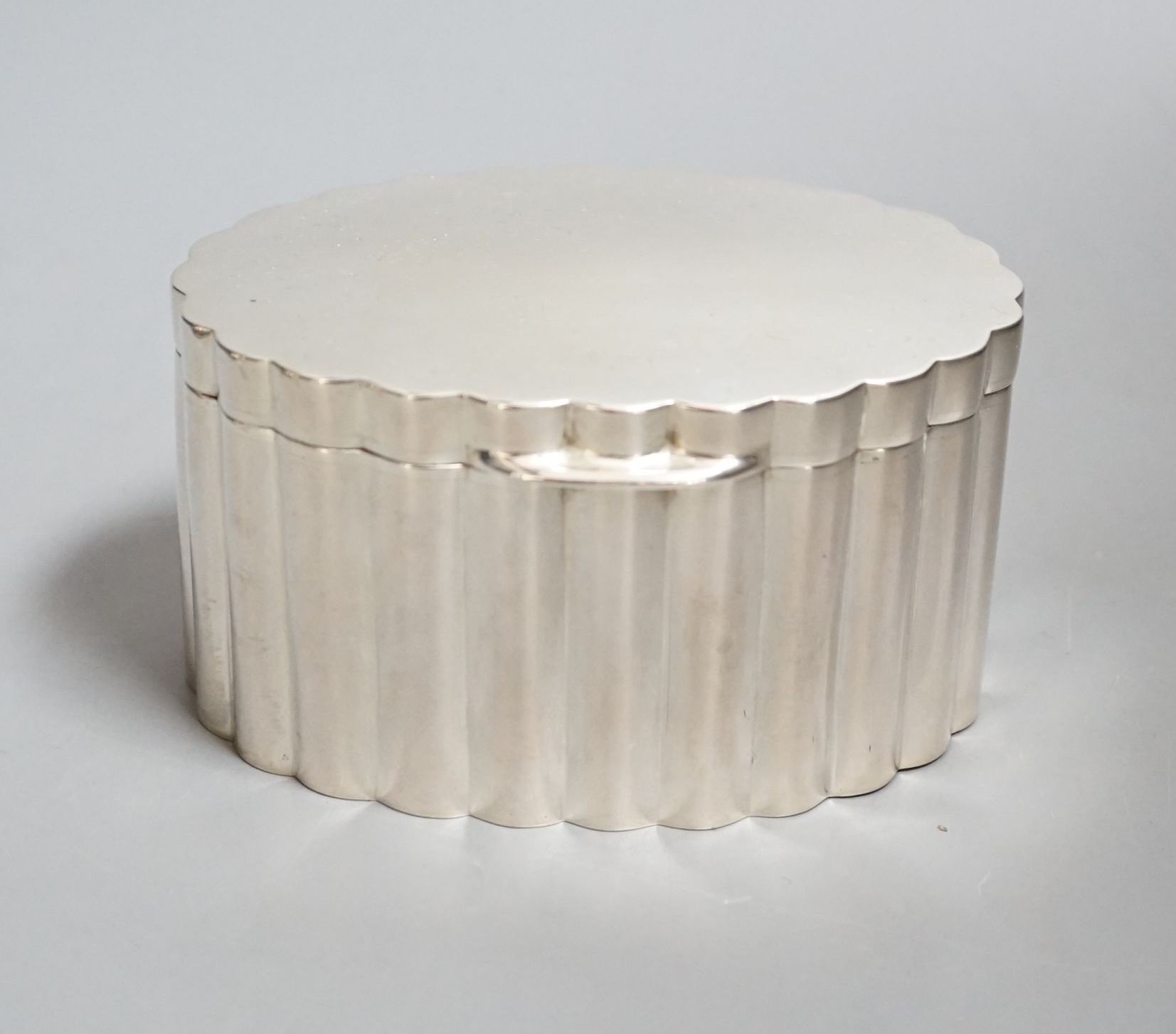 A fluted white metal oval sugar box, 13.3cm.